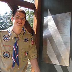 Eagle Scout Len Castro stands by kiosk he built to memorialize settlers.
