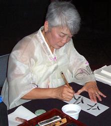 Patsy Suhr O'Connell, demonstrating traditional Korean calligraphy.