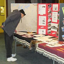 Audience member examines displays of tribal history and artifacts.