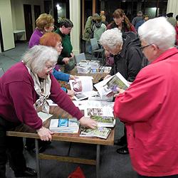 After the program, audience members flock to the table to get their signed first editions.